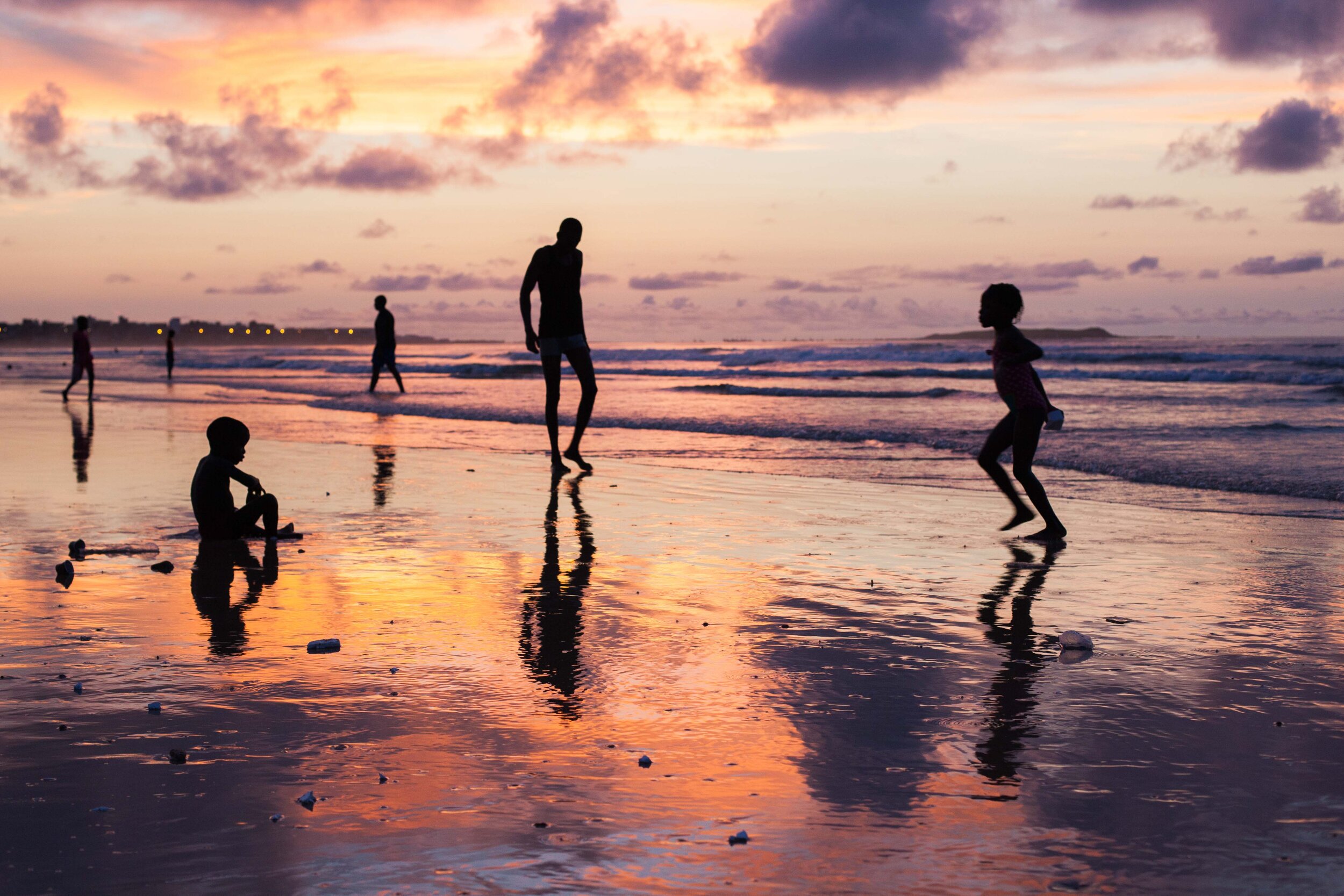 Silhouetted portraits on the beach at sunset in Dakar.