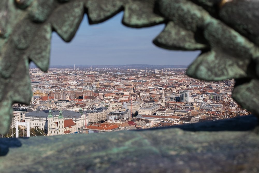 Views over Budapest framed from an archway at the top of Gellért Hill