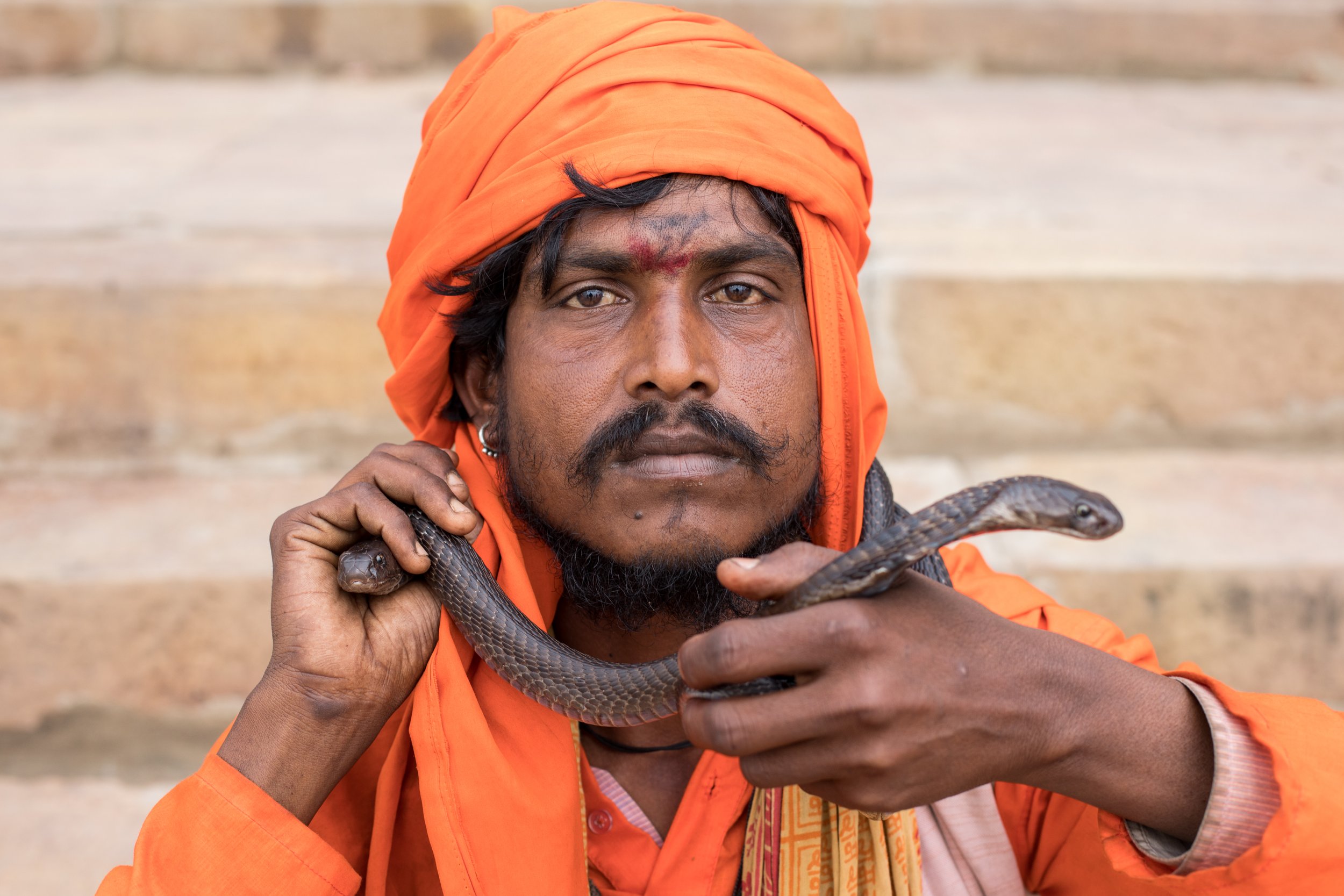 Street portrait, a snake charmer on the banks of the river Ganges in Varanasi, India