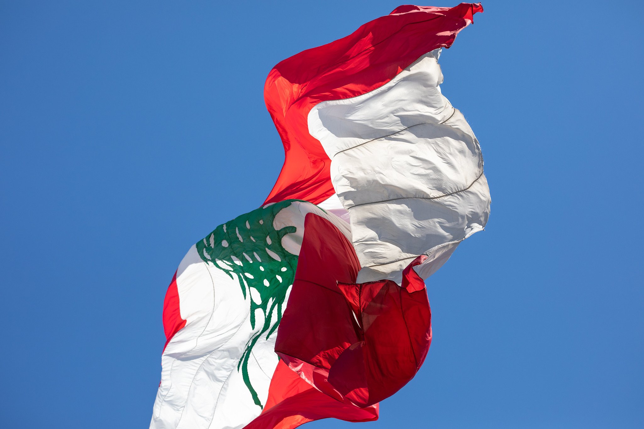 A large Lebanese flag flying against a blue sky in the Capital Beirut.  