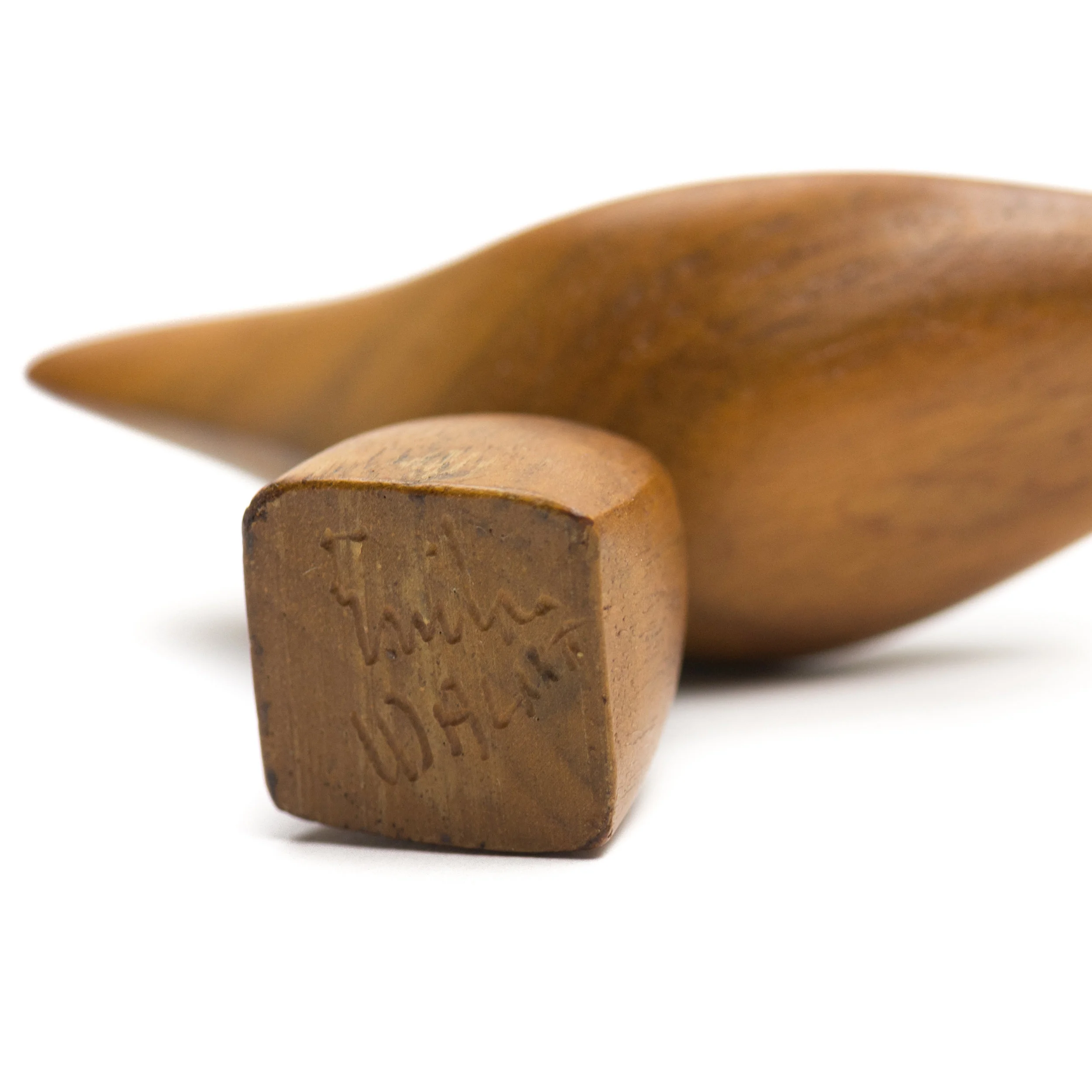 The bottom of the bird sculpture is signed by the artist along with the type of wood used.