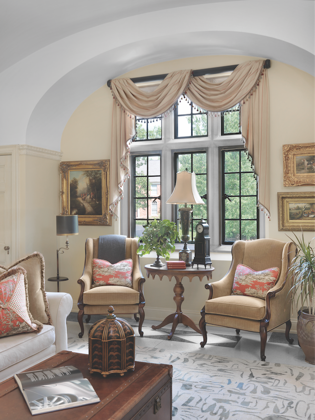 From the foyer, the main staircase splits at the landing, doubling back to a second-floor seating area, where an elegantly simple window treatment enhances the original casement windows. 