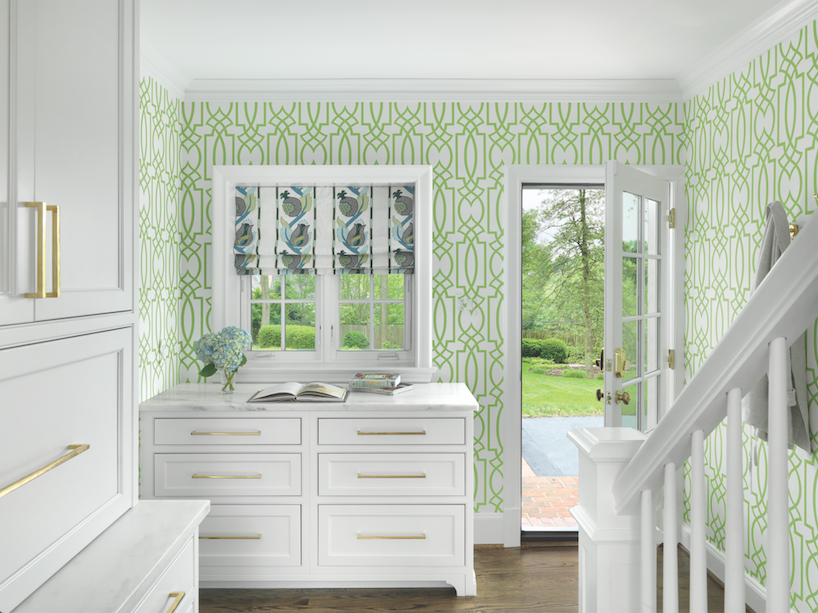 Too pretty to be the back entrance, the mudroom/rear staircase is springtime cheerful with custom white cabinetry and trellis wallpaper.