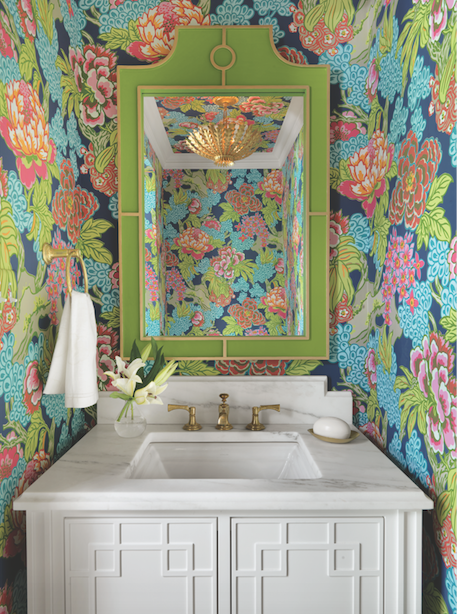 An existing powder room is artfully reinvented with a golden chandelier and spectacular wallpaper.