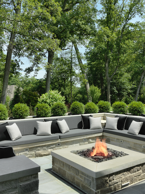 Cool evenings get cozy around the stone firepit, with built-in seating and lots of pillows.