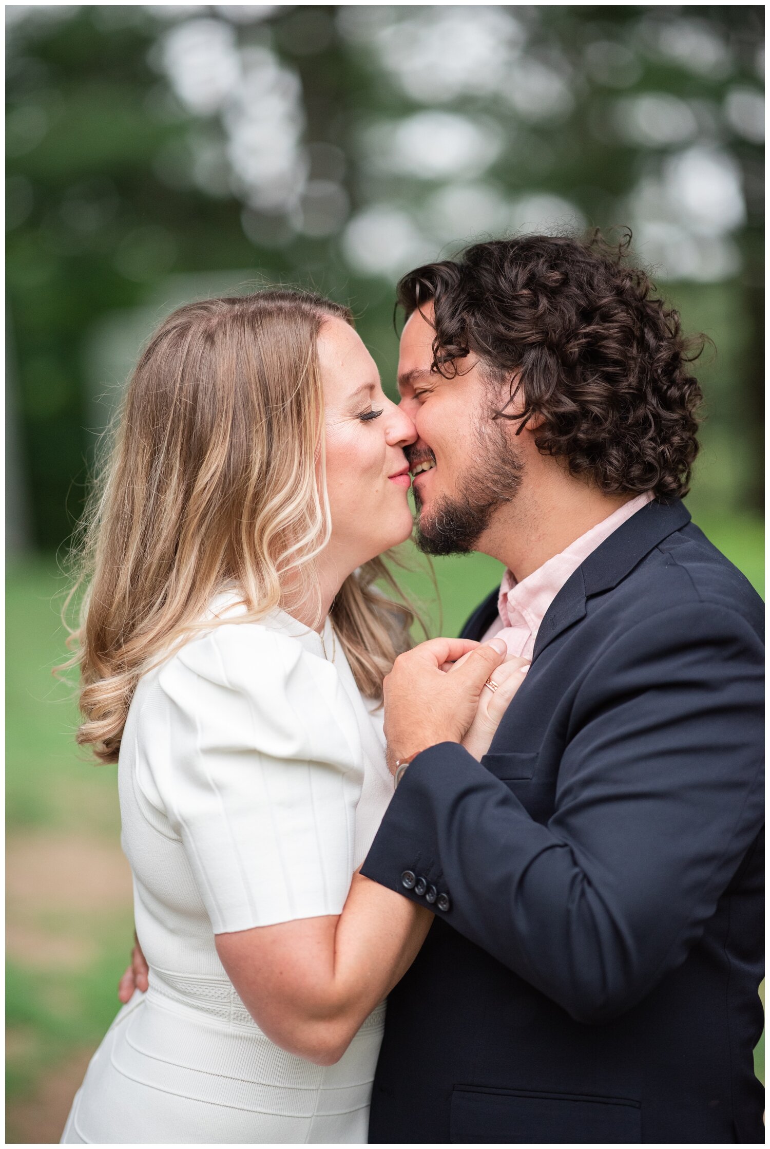 portrait of engaged couple kissing outdoors