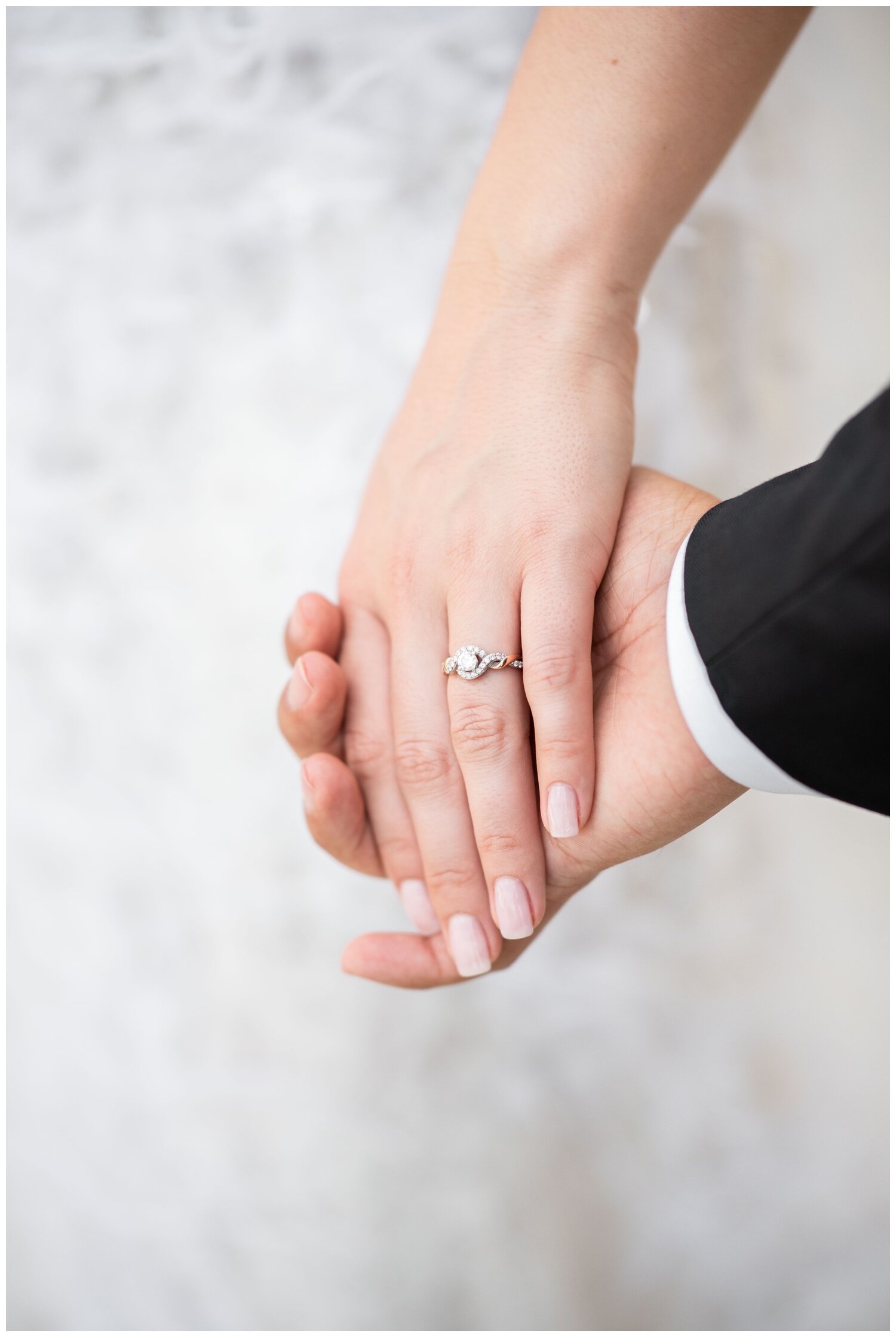 close up of bride and grooms hands together