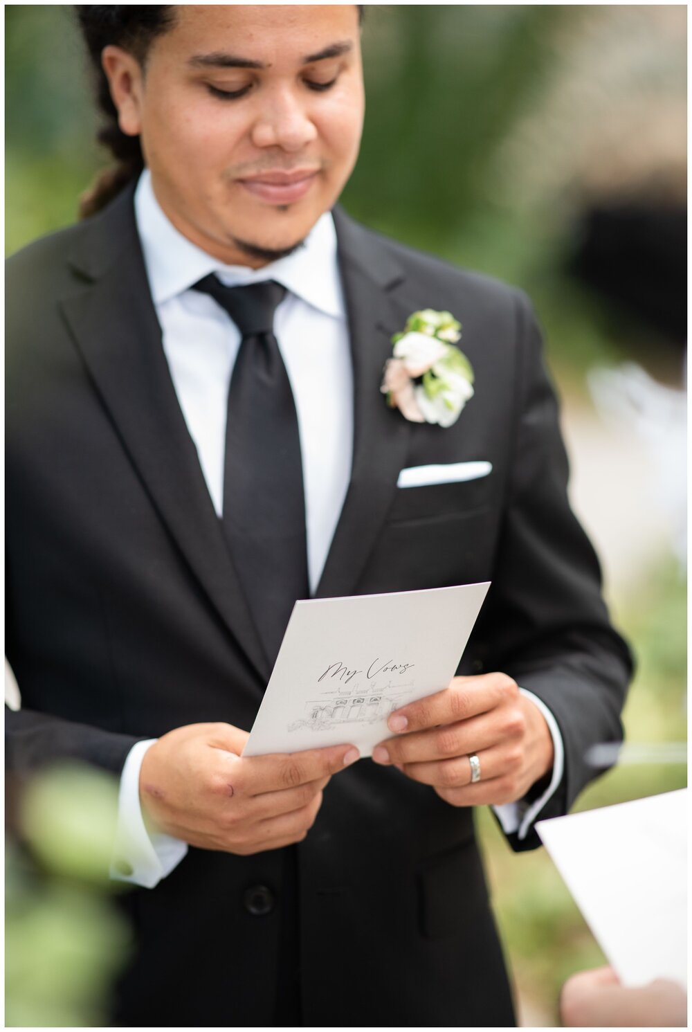 groom reading vows during garden elopement