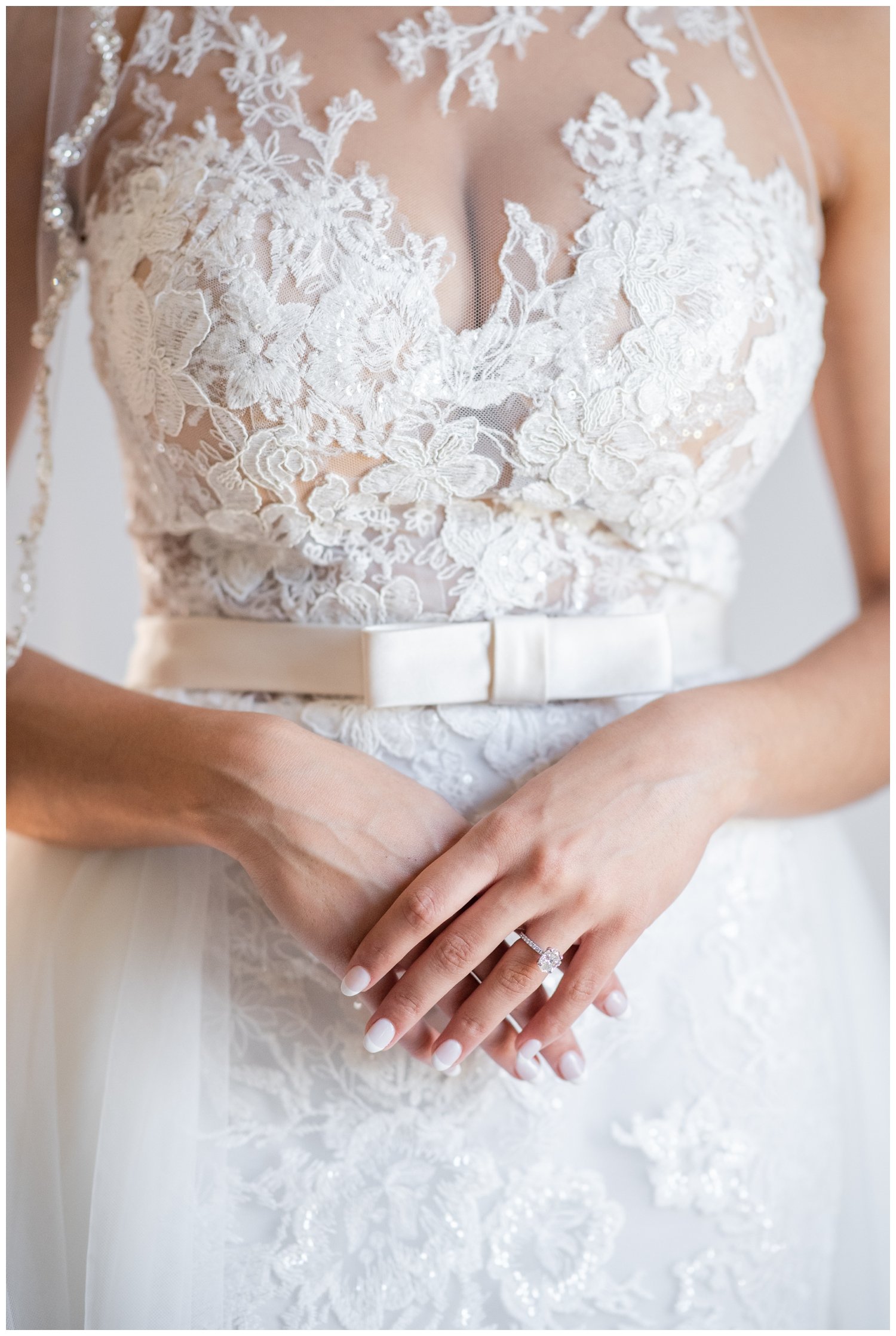 close up portrait of bride holding and crossing hands at her waist