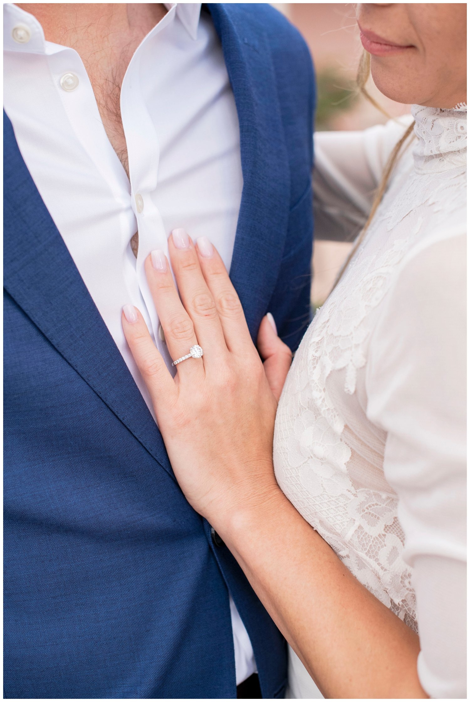 detailed shot of bride's hand with wedding ring on groom's chest