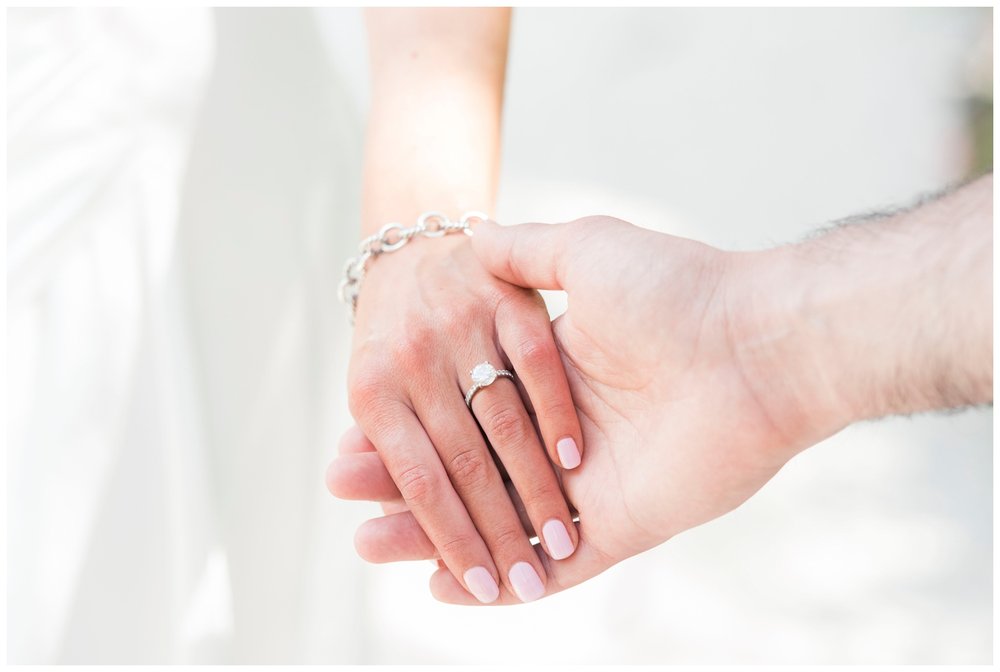 detailed shot of engaged couples hands clasping 