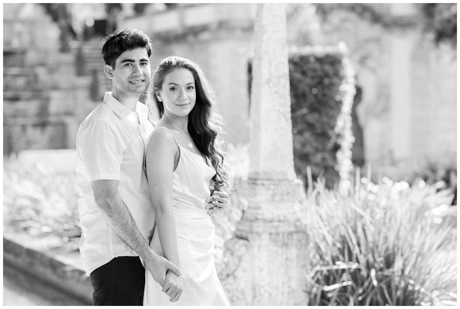 black and white image of engaged couple standing at the Vizcaya Museum and Gardens