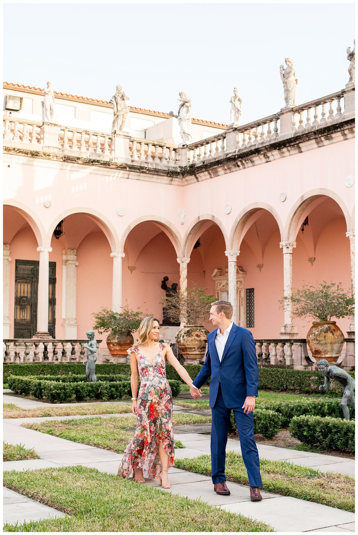 engaged couple holding hands and walking inside the grounds at Ringling Museum Florida