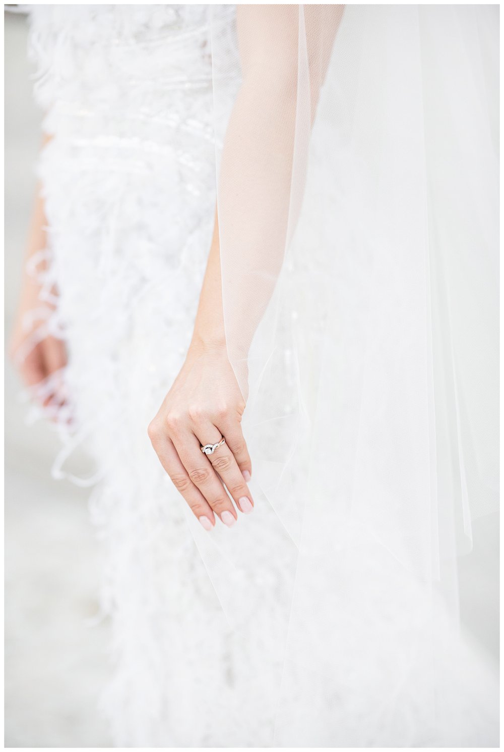 closeup of bride's hand with wedding holding her veil by her side