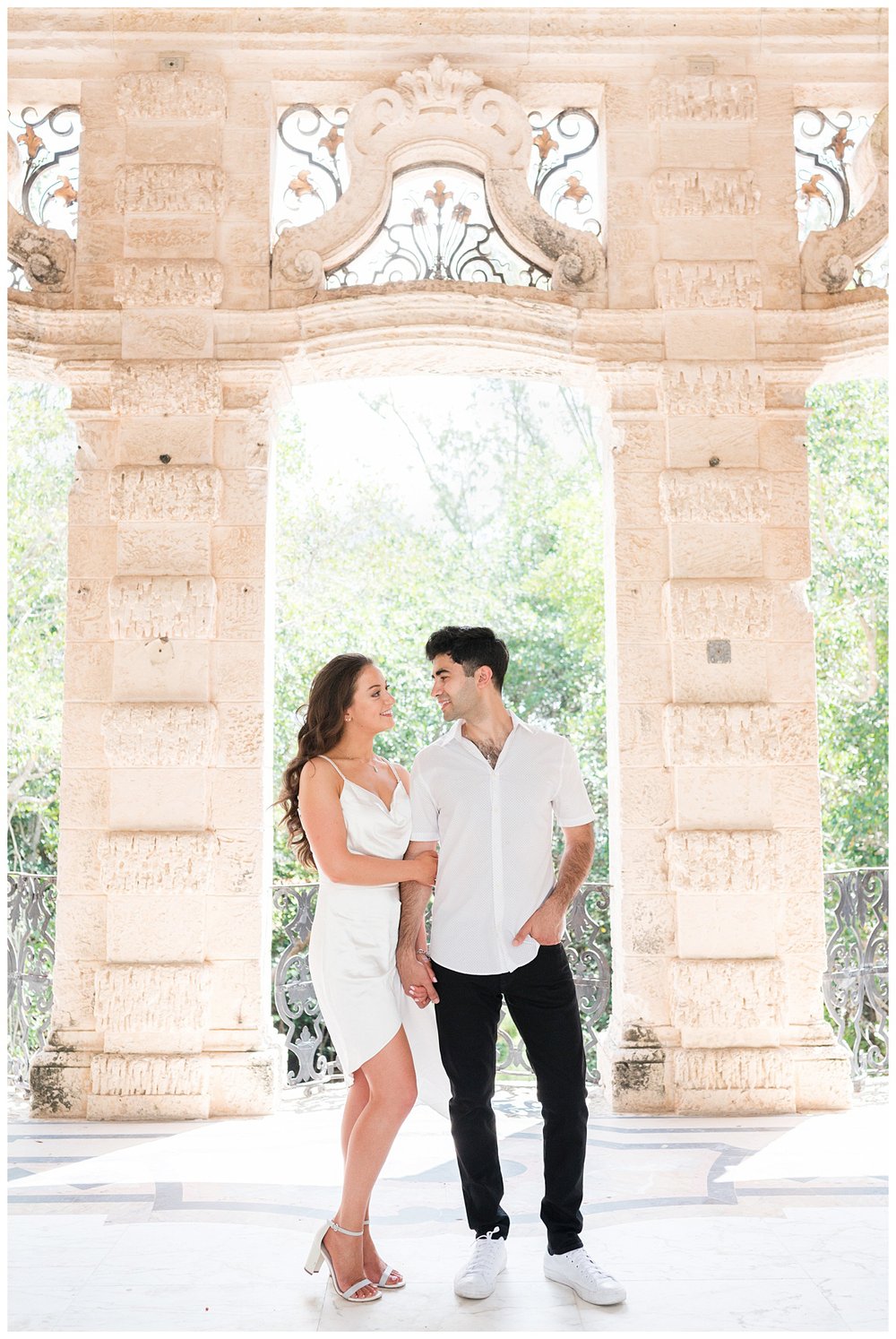 engaged couple standing under arches at Vizcaya Museum and Gardens