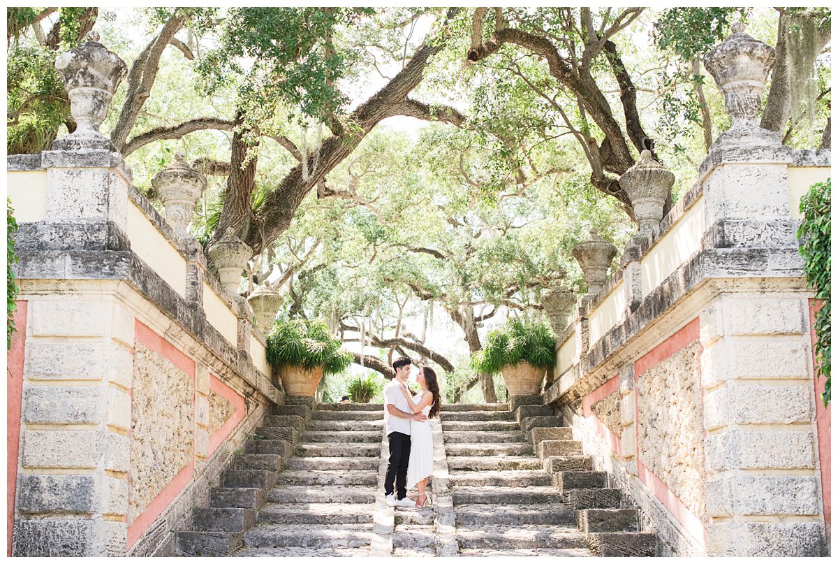 Vizcaya Museum engagement photos with couple standing on stairs under the trees