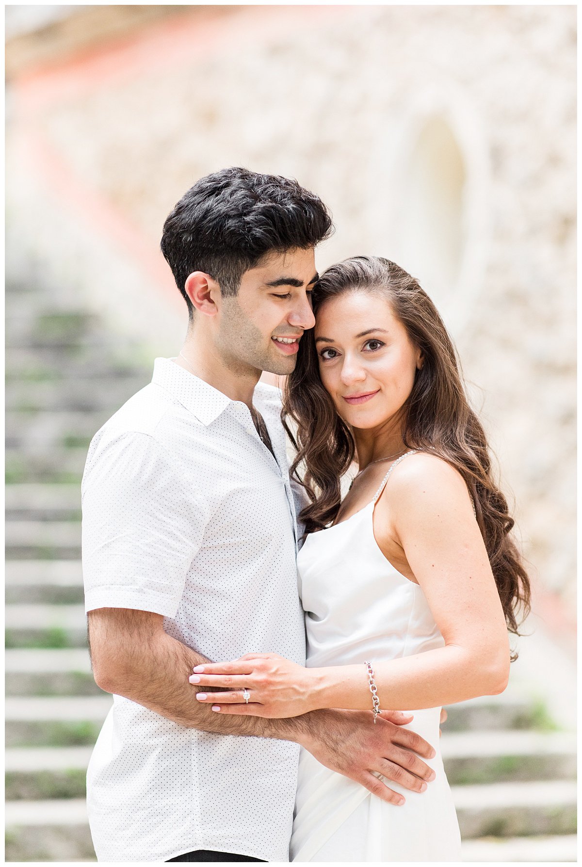 hugging embrace of engaged couple in white dress and white shirt