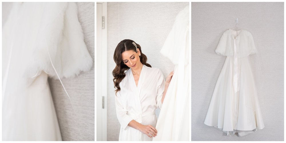 bride in white robe touching wedding gown and posing for Boston wedding photographer