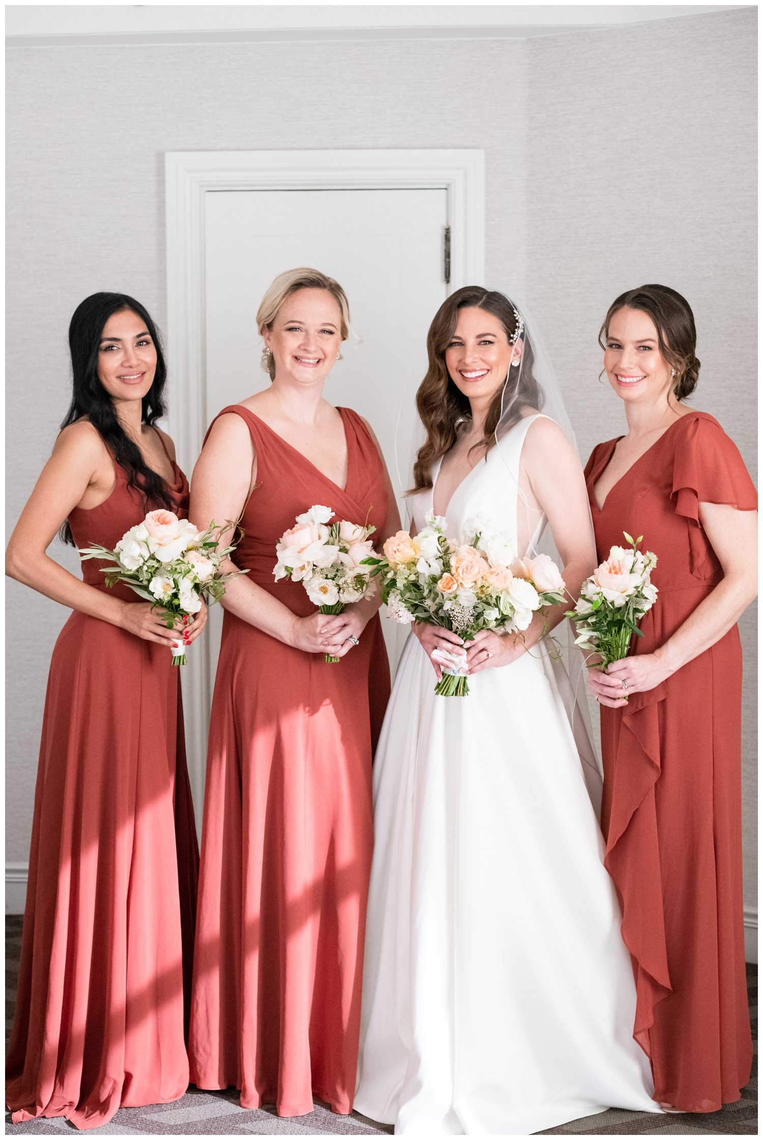 bridesmaids in rust colored dresses with bride