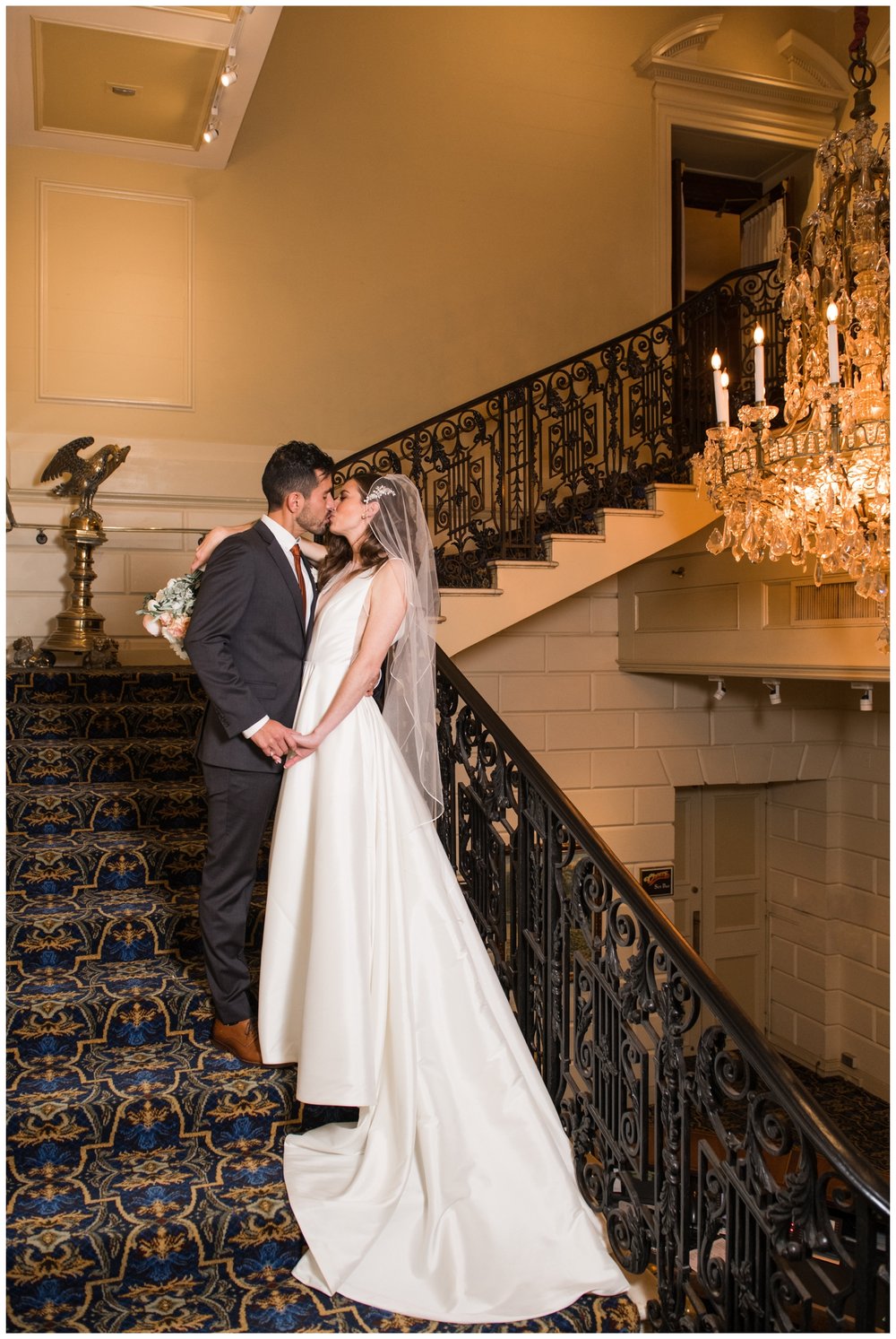 newlyweds standing on Hampshire House staircase posing for Boston wedding photographer