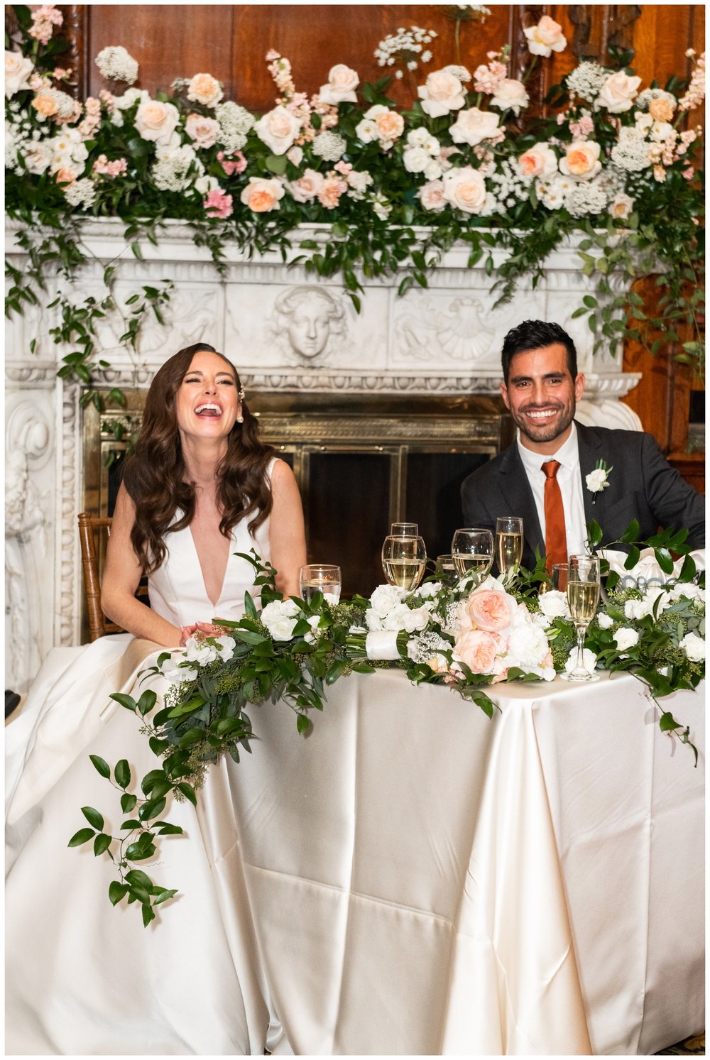 bride and groom laughing sitting at sweetheart table Boston wedding reception