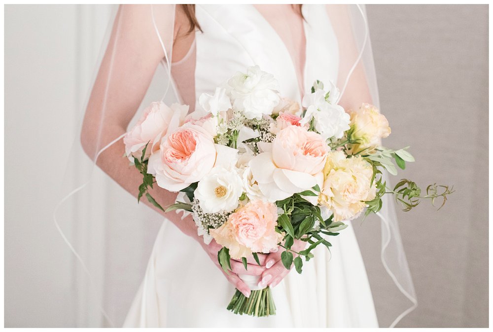 detailed image of bride's hands holding floral bouquet