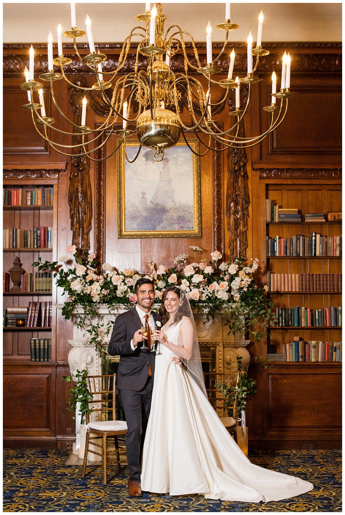 newlyweds toasting in front of fireplace with florals Boston wedding photographer