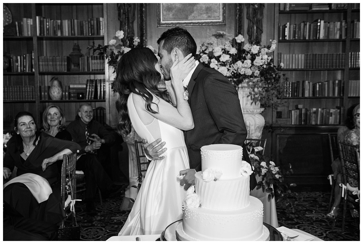 bride and groom kissing after cake cutting Boston wedding photographer
