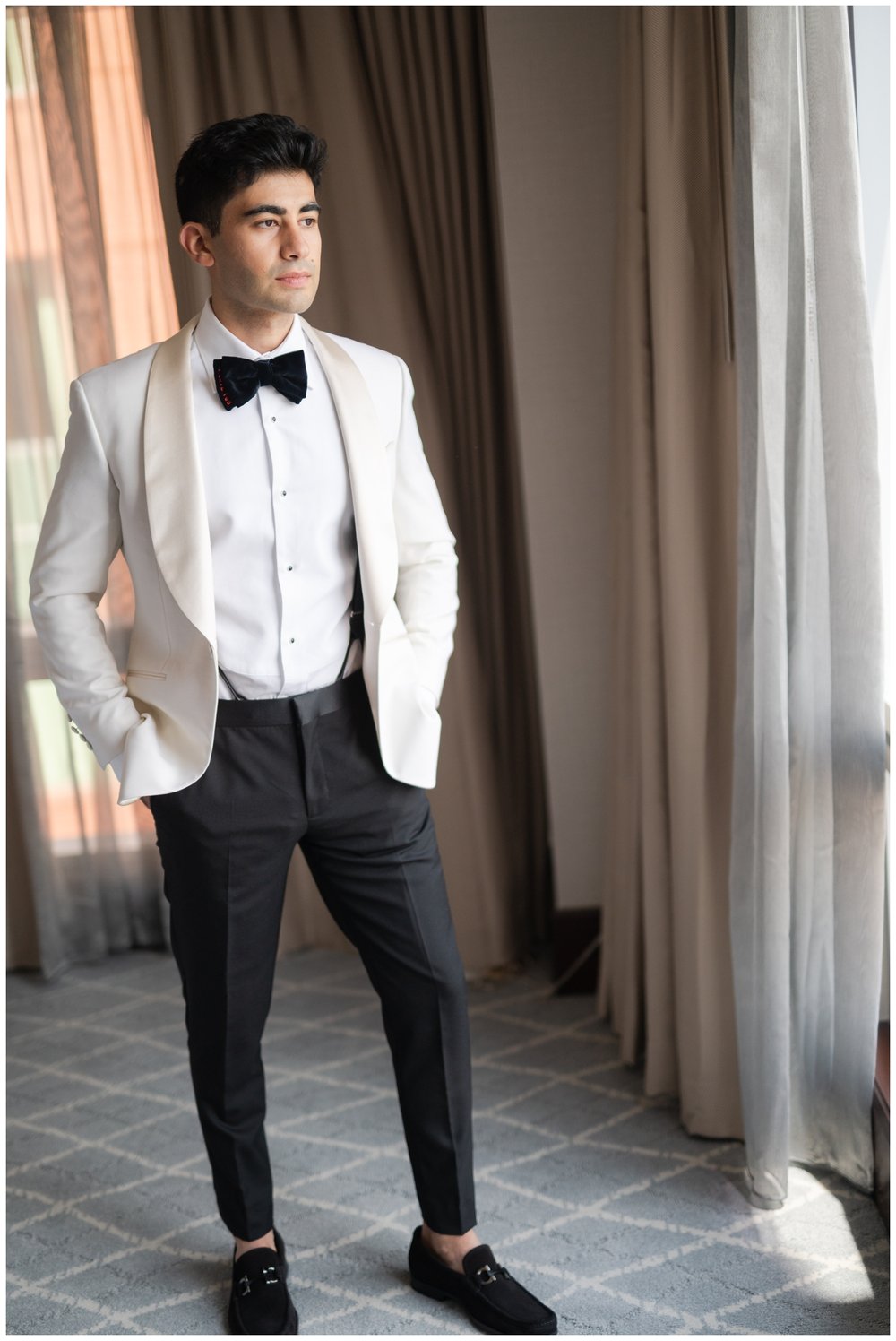 groom in white tux jacket black pants and bowtie
