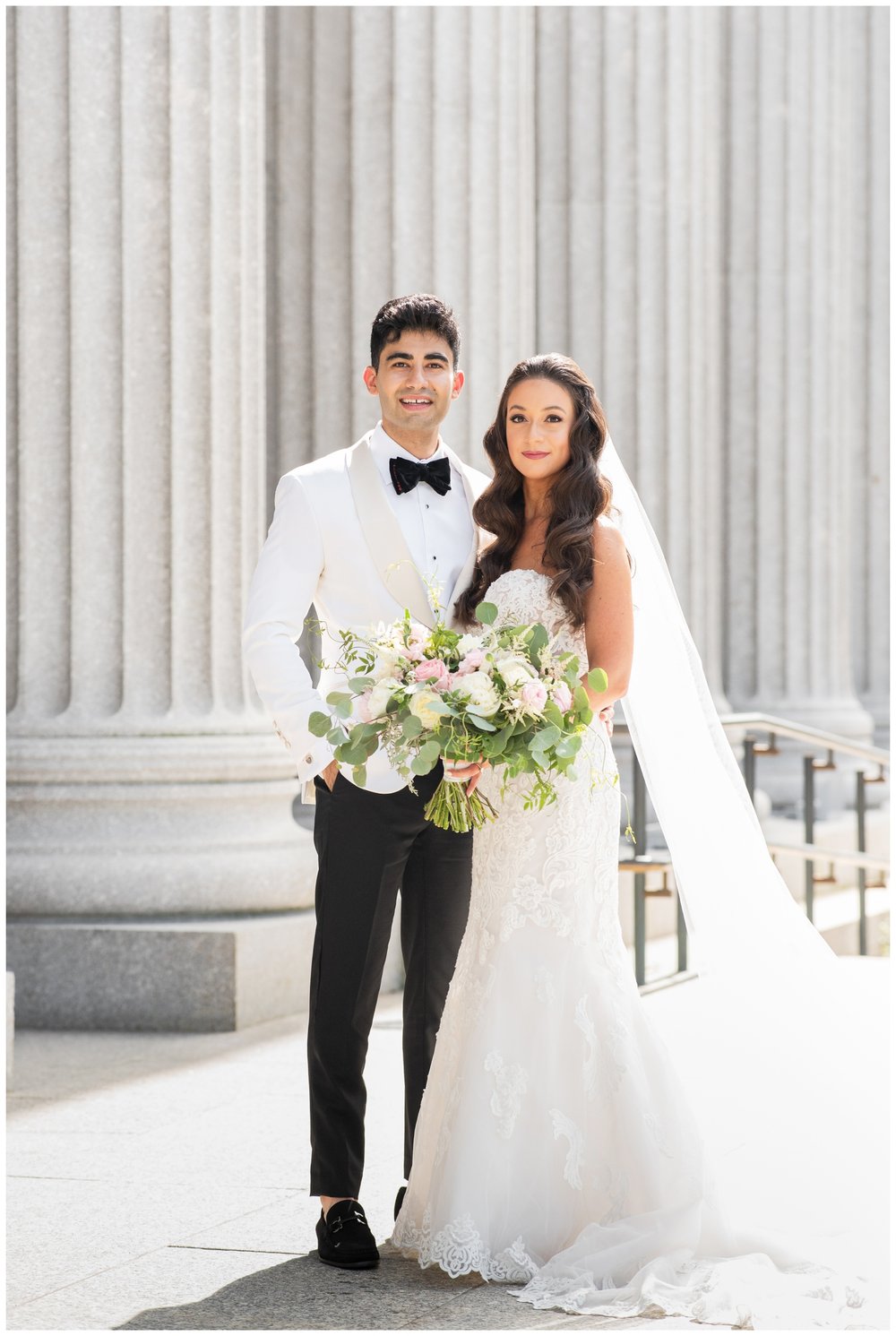 bride and groom portrait standing outside by white columns
