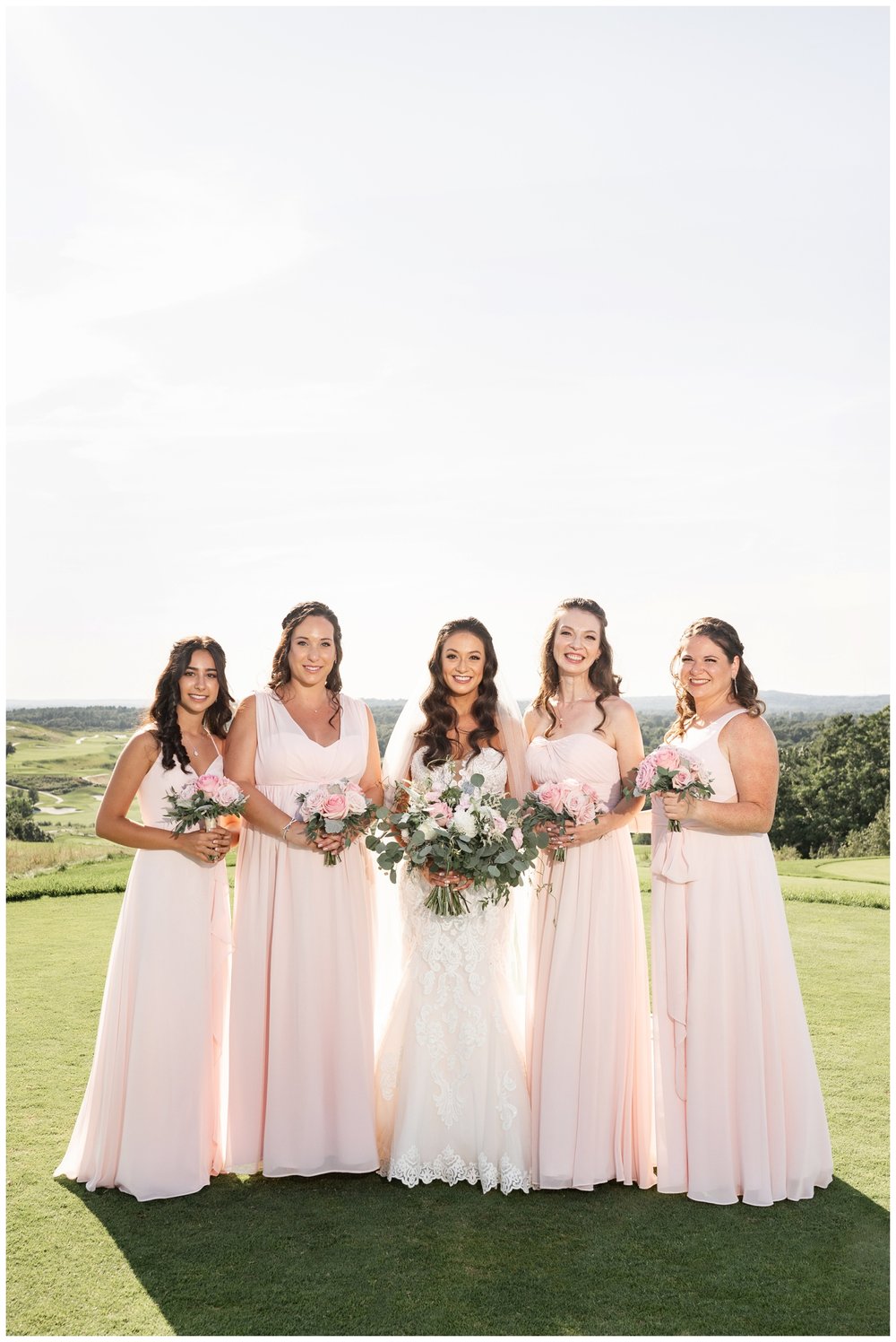 bride and bridesmaids in pink dresses standing on golf course Granite Links