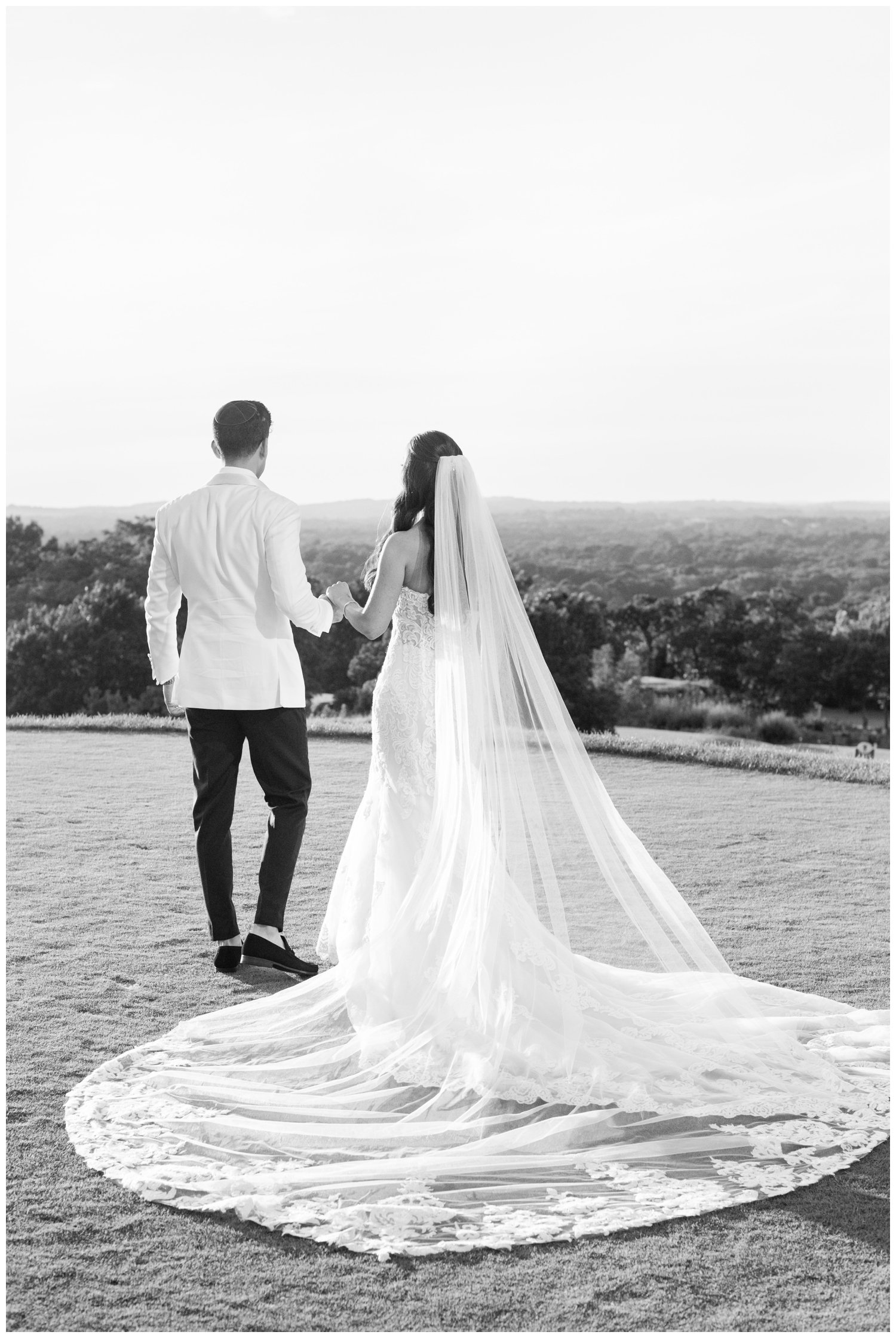 black and white portrait of bride and groom looking into sunset