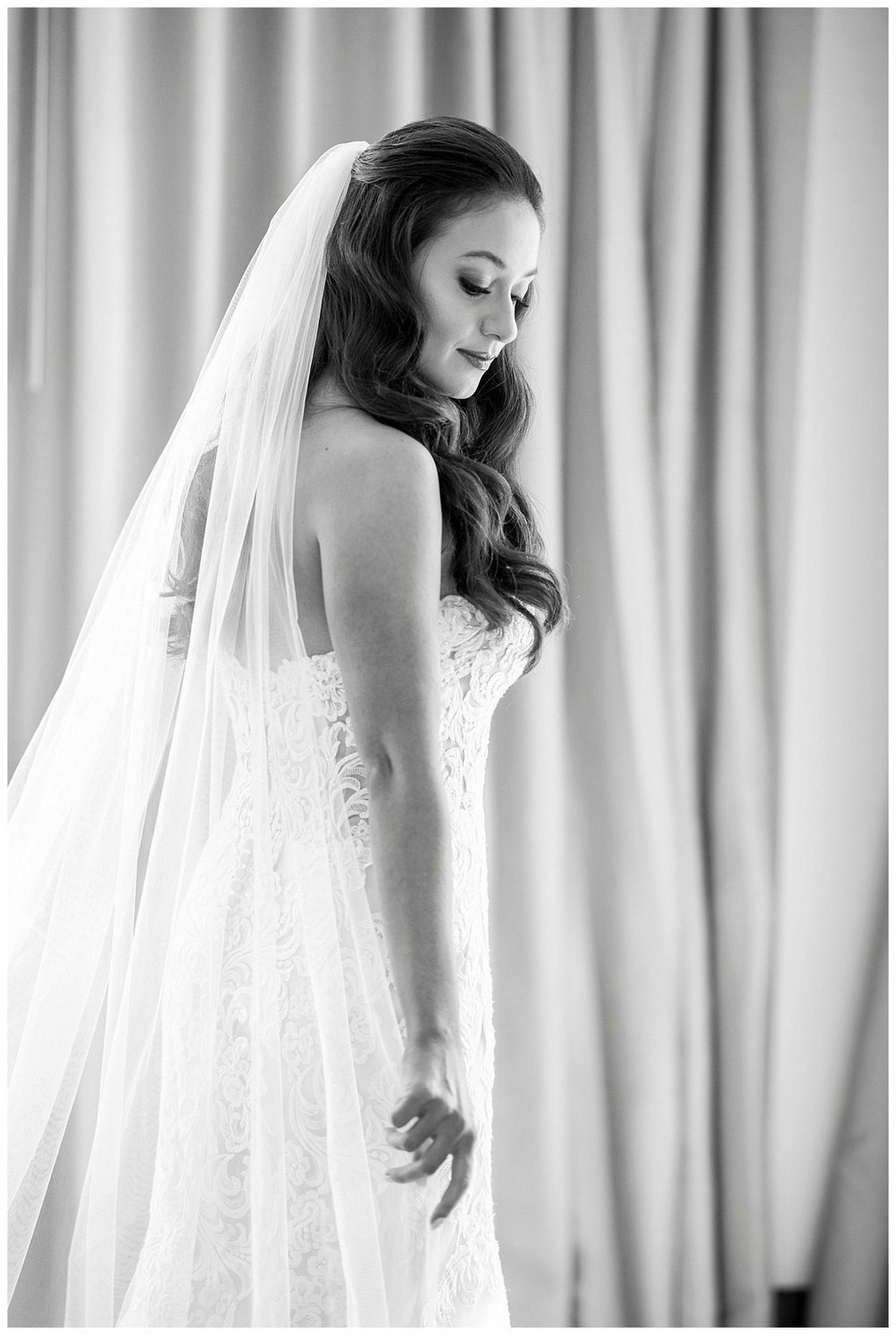 black and white portrait of bride standing looking down at the ground