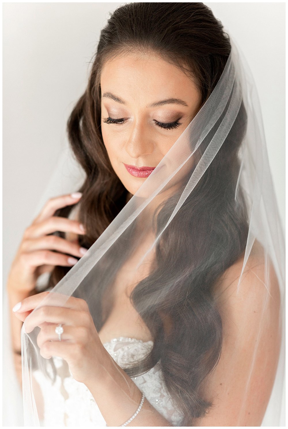 bridal portrait closeup of bride looking at veil 