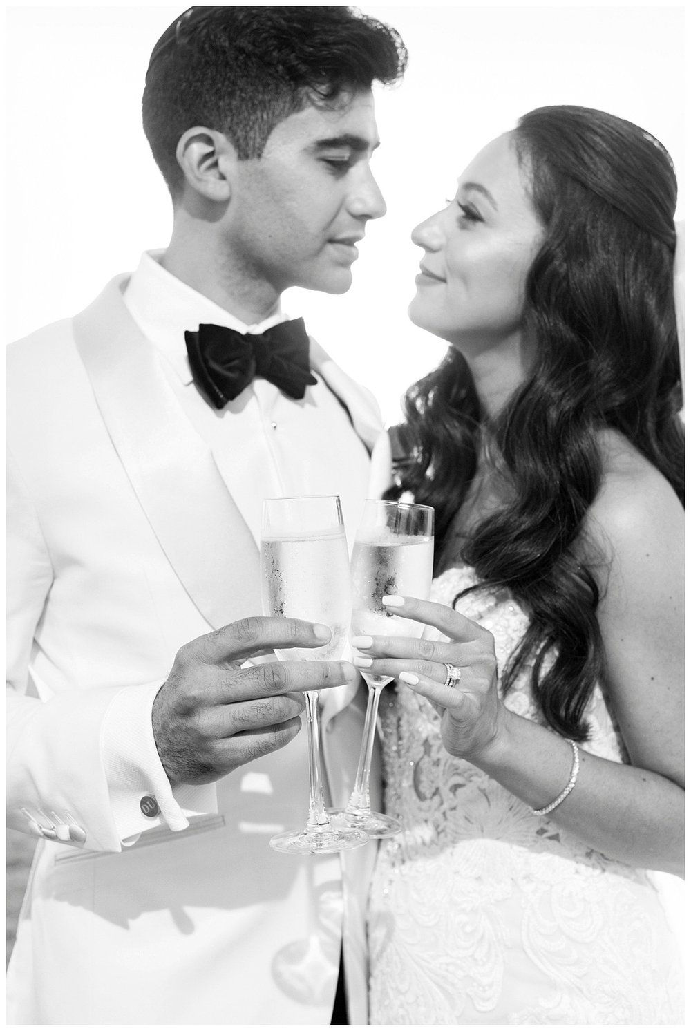 black and white image of newlyweds holding champagne glasses