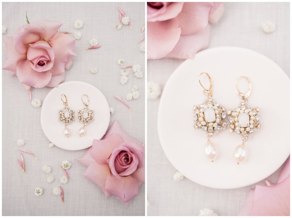 pearl earrings in white dish with blush florals on flatlay