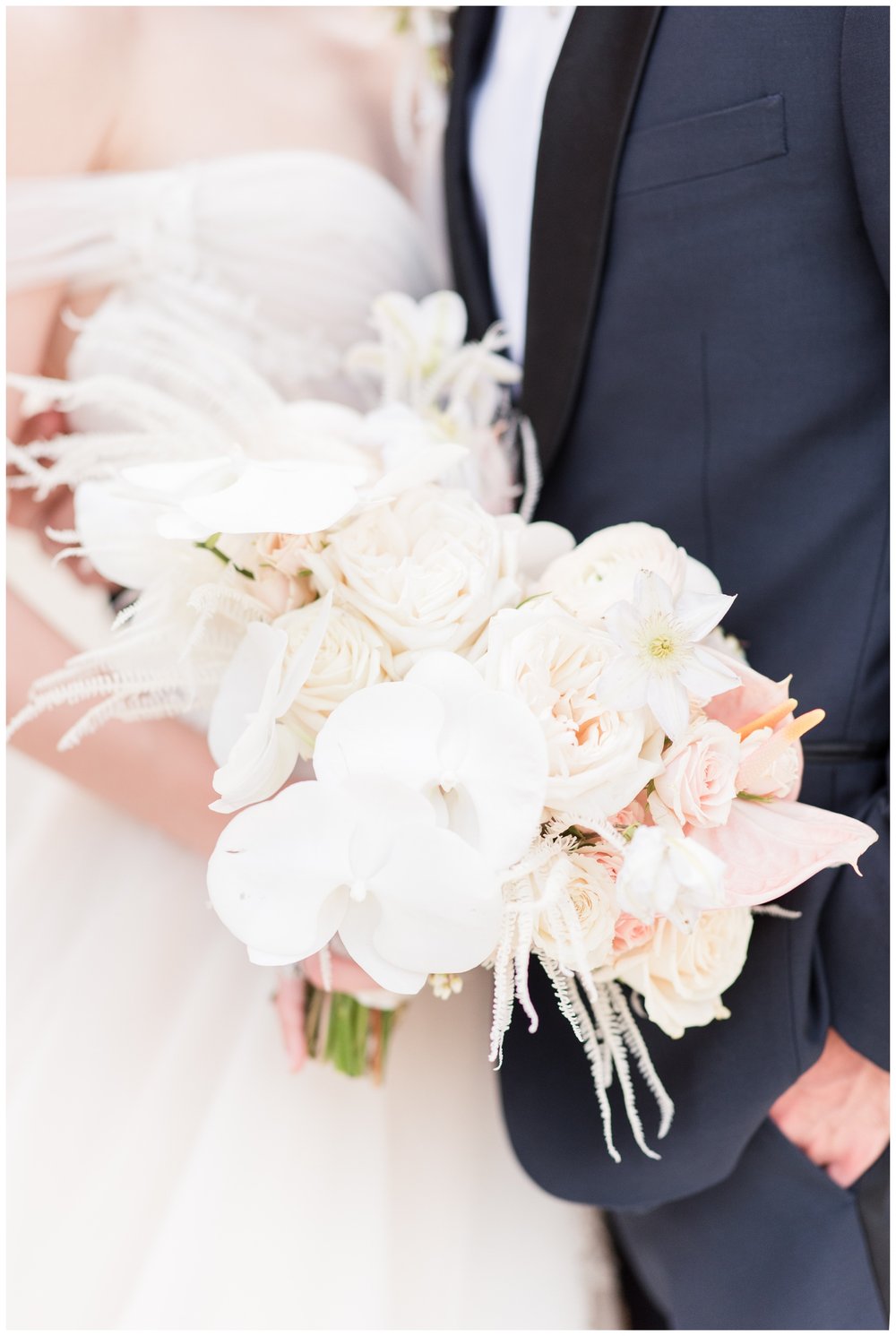 detailed image of bride and groom hands on white and blush wedding bouquet