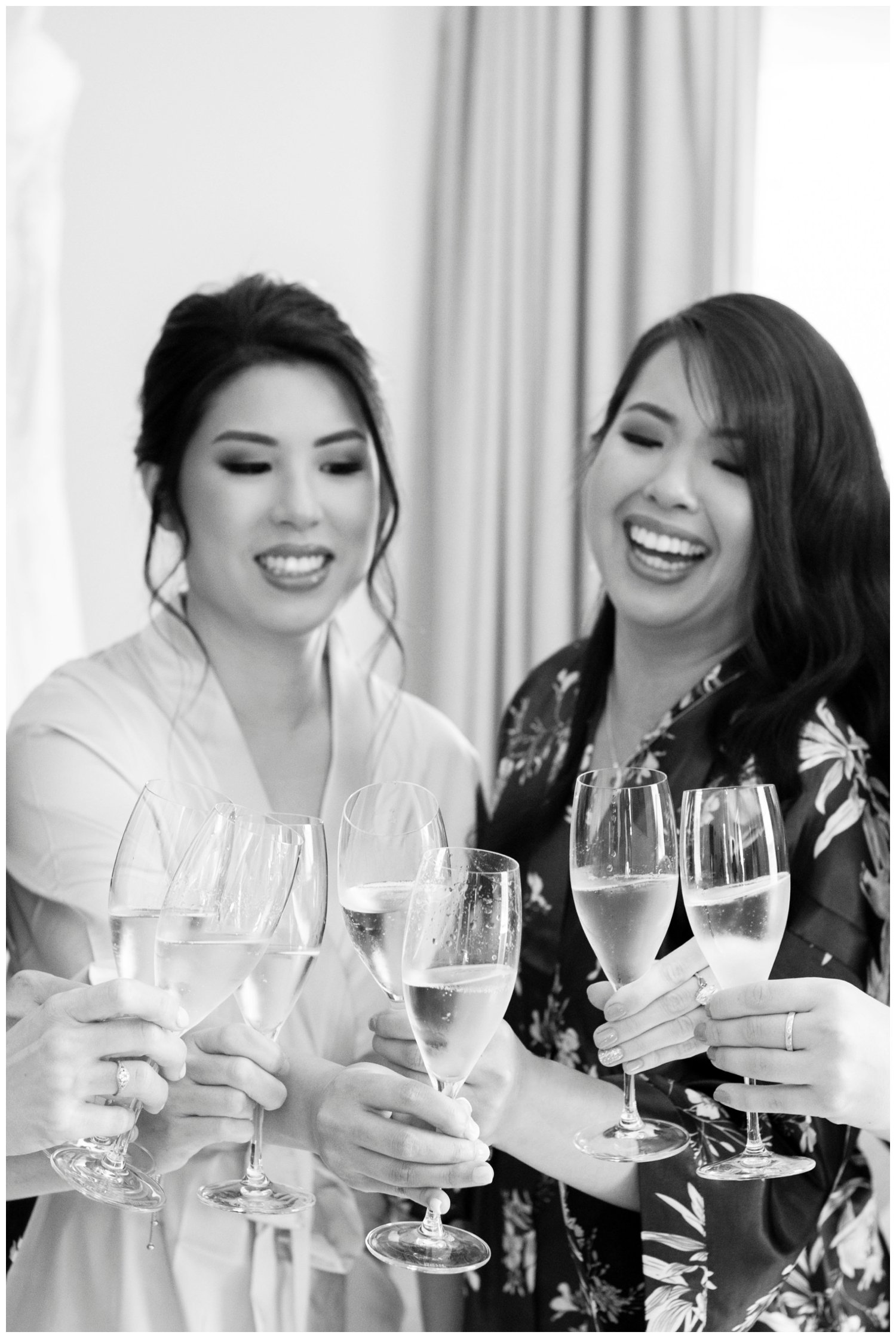 bride toasting with a bridesmaid and laughing