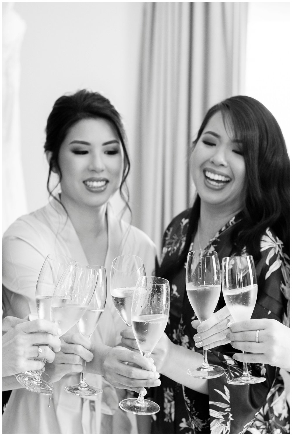 bride toasting with a bridesmaid and laughing