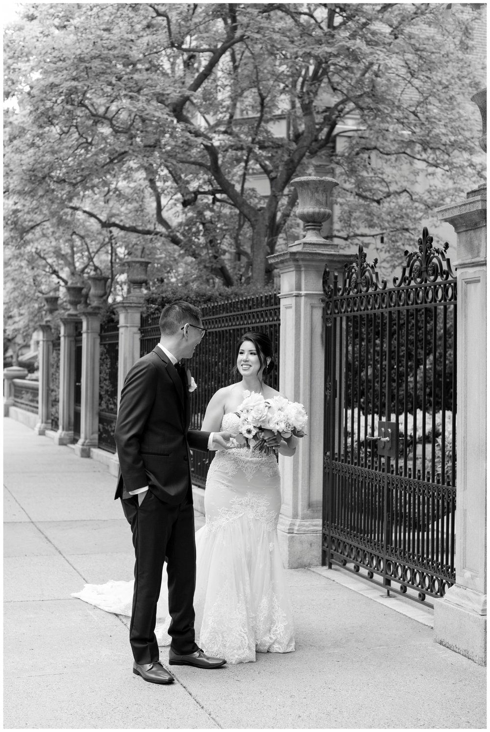 black and white image of bride and groom holding hands walking outside The Newbury Hotel wedding
