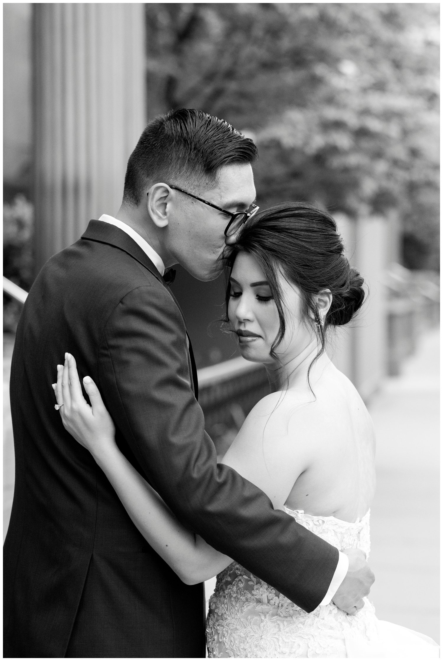 black and white portrait groom kissing top of bride's head