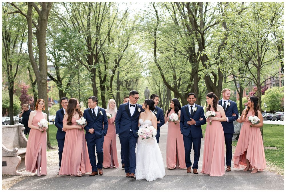 bride and groom walking outdoors with bridal party