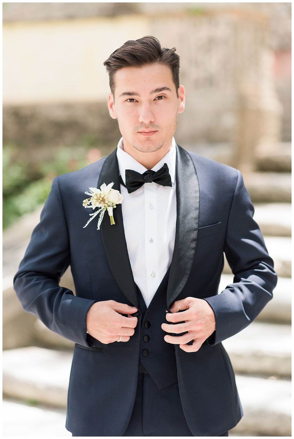 groom fastening black tux jacket portrait