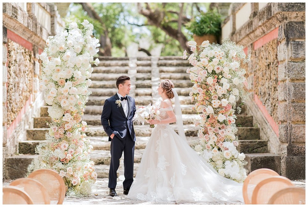 bride and groom portrait outdoors surrounded by floral columns at Miami Vizcaya Museum Wedding