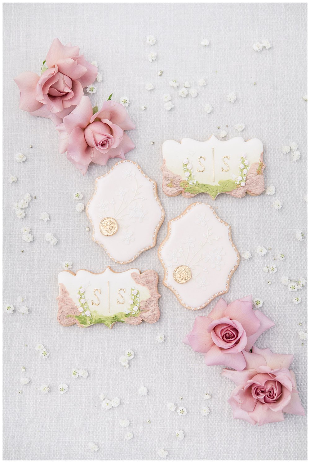 blush and white wedding cookies surrounded by blush florals