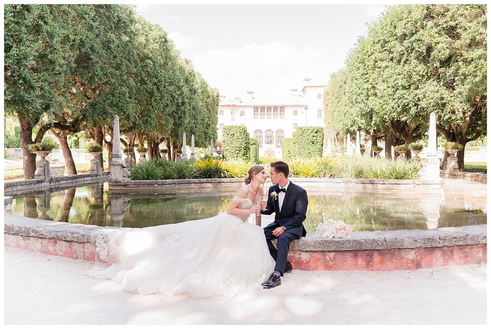 bride and groom sitting in front Miami Vizcaya Museum fountain
