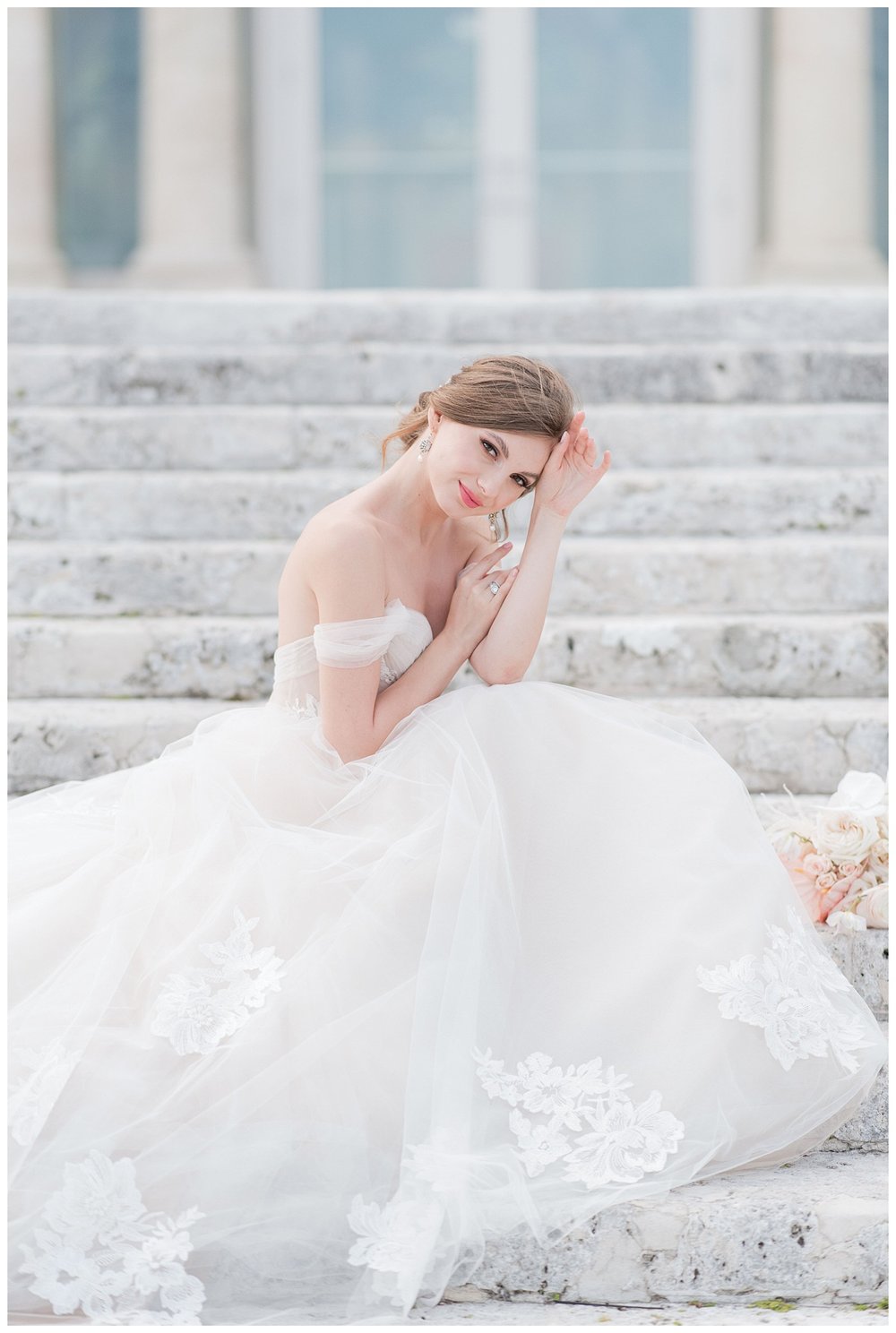  bride sitting on steps at Miami Vizcaya Museum Wedding with hand in hair 