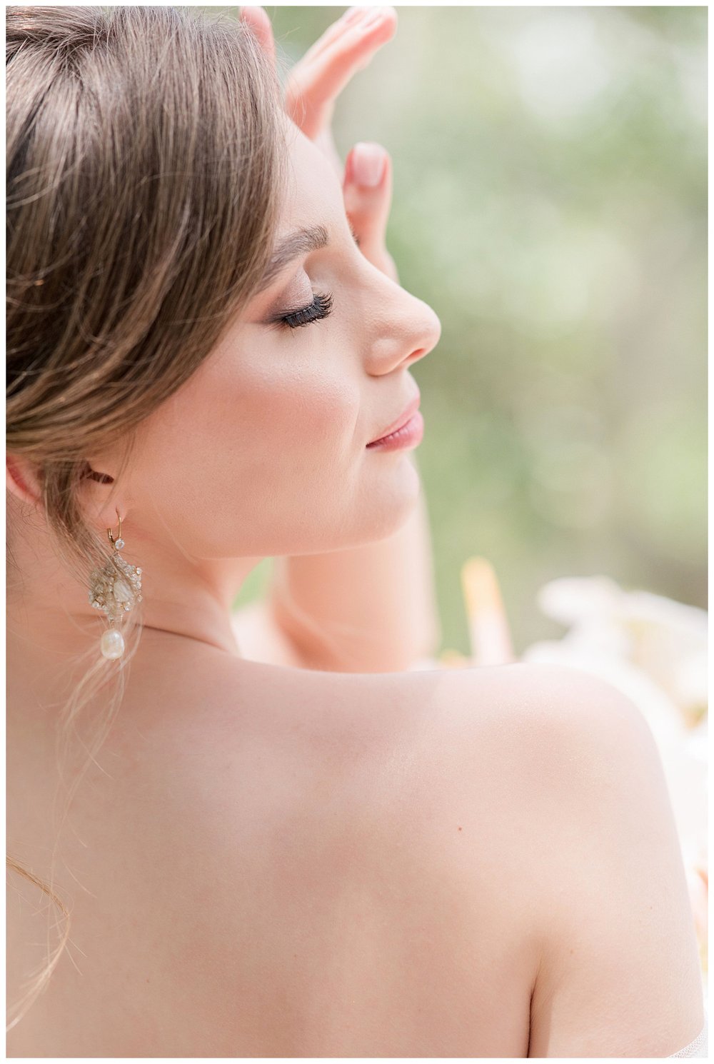bride posing with eyes closed and hand on forehead outdoor bridal portrait