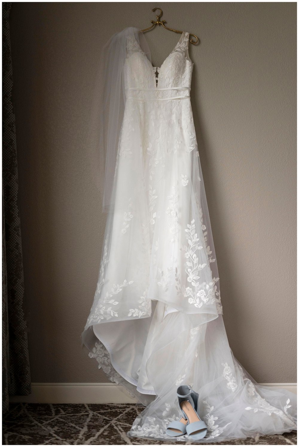 white wedding gown hanging on a door frame
