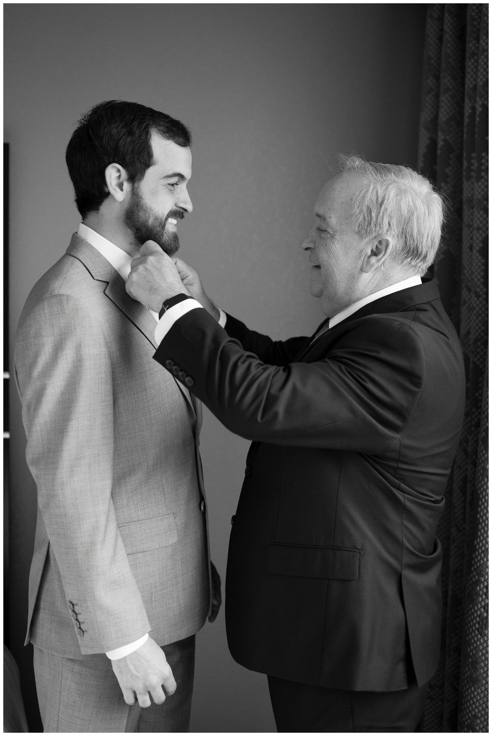 groom getting ready with father fastening tie